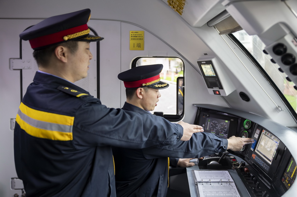 3月4日，“周恩來號(hào)”機(jī)車司機(jī)俞神杰（左）、陳辰（右）在對(duì)監(jiān)控進(jìn)行確認(rèn)。
