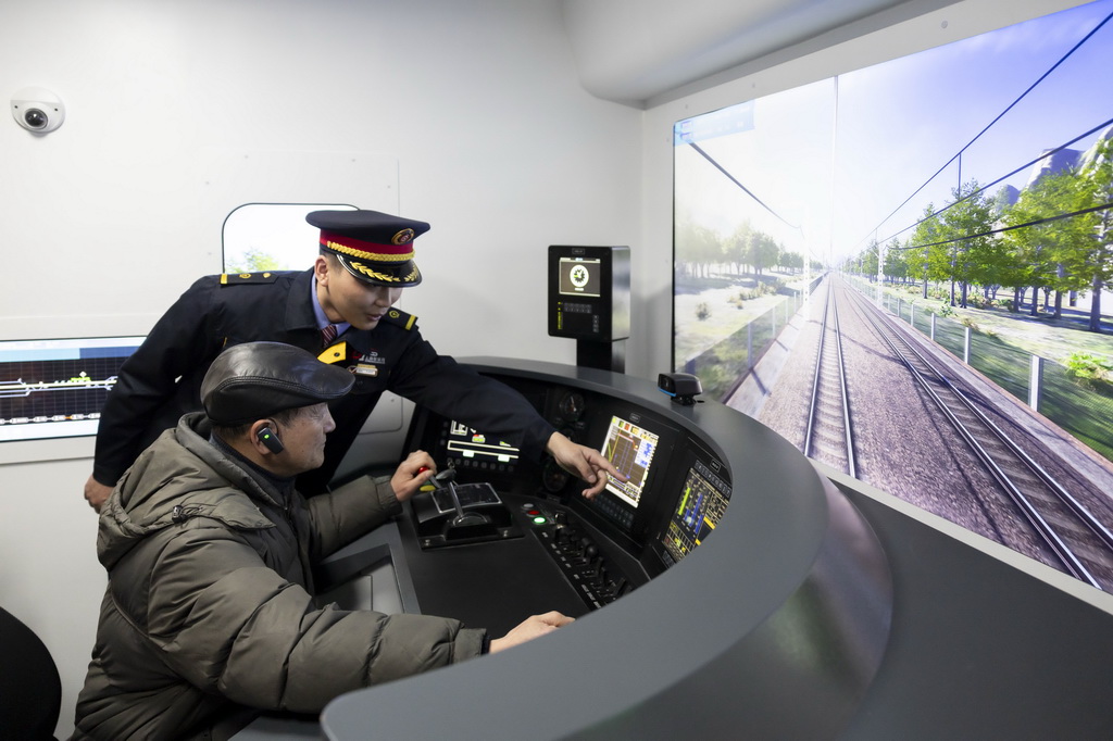 3月4日，第一代“周恩來(lái)號(hào)”機(jī)車(chē)組成員、首發(fā)副司機(jī)王蘇生（前）在“周恩來(lái)號(hào)”機(jī)車(chē)展室體驗(yàn)?zāi)M駕駛。